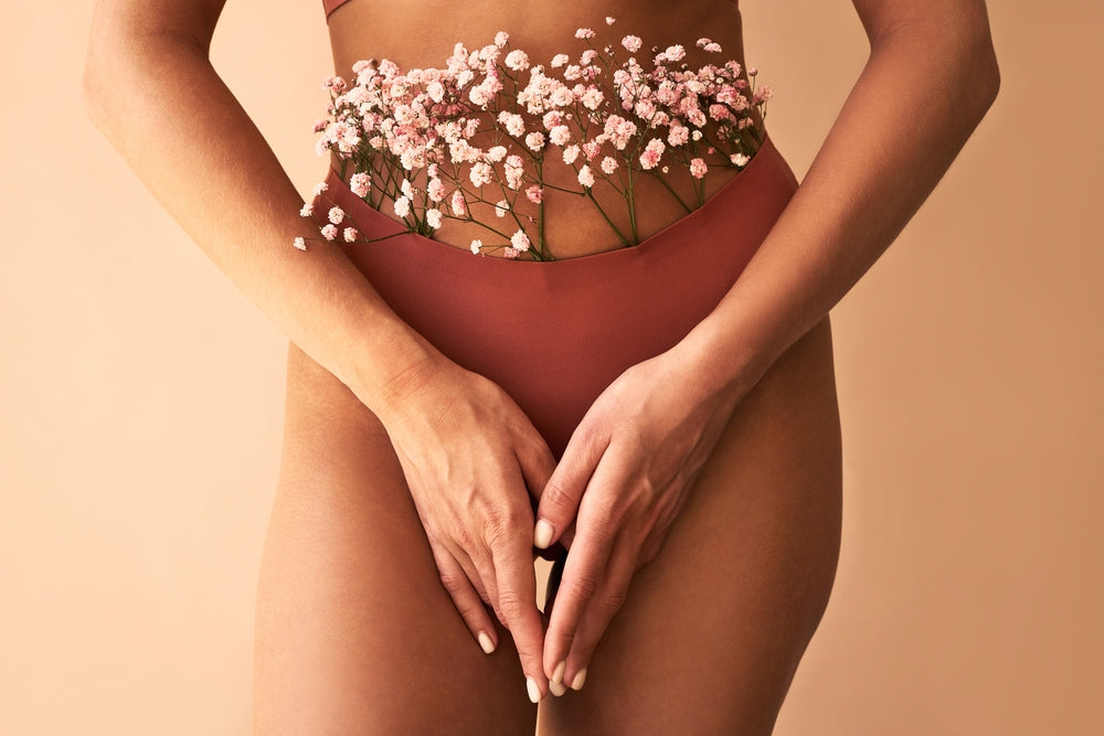 Femme en culotte plaçant ses mains devant son entrejambe