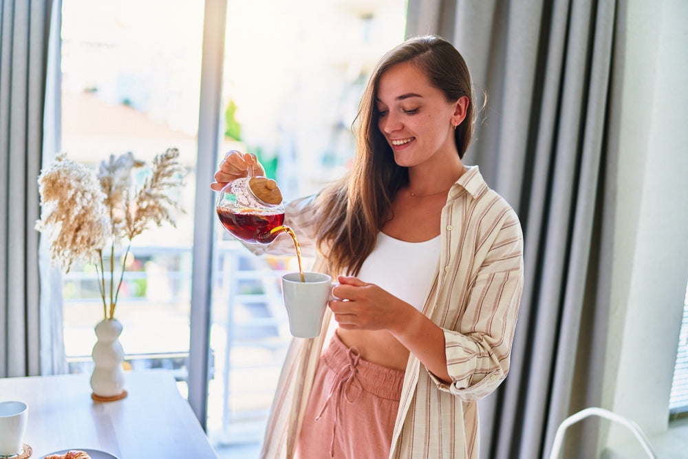 Femme versant du thé dans une tasse